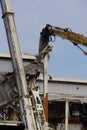 A modern steel structure building being demolished by a machine Royalty Free Stock Photo