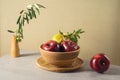 Modern still life composition with red apples, pomegranate and olive leaves