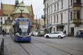 Modern streetcar moving through historic city center of Krakow
