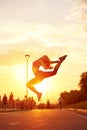 Modern style dancer woman jumping. Dancer silhouette at sunset. Contour of girl on urban city background Royalty Free Stock Photo