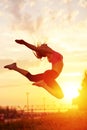 Modern style dancer woman jumping. Dancer silhouette at sunset. Contour of girl on urban city background Royalty Free Stock Photo