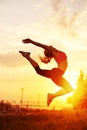 modern style dancer woman jumping. Dancer silhouette at sunset. Contour of girl on urban city background Royalty Free Stock Photo