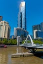 Modern style Evan Walker Bridge leads across Yarra River to Southbank and tall Eureka Tower