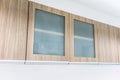 Modern style wood cabinet with glass doors hanging on wall Royalty Free Stock Photo