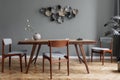 Stylish dining room with wooden table and vintage chairs.