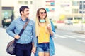 Modern stylish happy couple walking together on city centre street holding hands and smiling Royalty Free Stock Photo