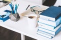 Modern stylish office work place with open book, glasses, office supplies and books, desk work concept in white and blue colors Royalty Free Stock Photo