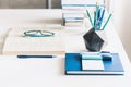 Modern stylish office work place with open book, glasses, office supplies and books, desk work concept in white and blue colors Royalty Free Stock Photo