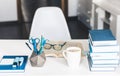 Modern stylish office work place with open book, glasses, office supplies and books, desk work concept in white and blue colors Royalty Free Stock Photo