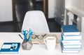 Modern stylish office work place with open book, glasses, office supplies and books, desk work concept in white and blue colors Royalty Free Stock Photo
