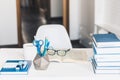 Modern stylish office work place with open book, glasses, office supplies and books, desk work concept in white and blue colors Royalty Free Stock Photo