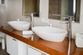 Modern stylish washbasins with chrome taps. Luxury lifestyle. Close-up, selective focus Wood texture Royalty Free Stock Photo