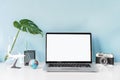 Modern and stylish workspace mock up with blank laptop and desk office supplies with color background and copy space