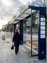 Modern suburban public bus stop and lady walking in front