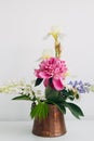 Modern summer flowers still life arrangement in vintage vase on white wood. Creative floral image. Stylish peony, lupin, iris and Royalty Free Stock Photo