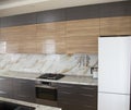 Modern and sunny kitchen with marble floor, elements of the working part. Moving. Wooden panels. Facades. Wood texture. Design, in