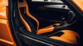 Modern orange supercar interior with the leather panel, sport seats, multimedia, and digital dashboard. View from the