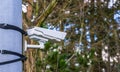 Modern surveillance camera mounted on a simple way with bands, security in nature and parks