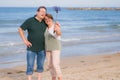 Modern sweet and loving mature couple taking selfie portrait- senior retired husband and wife on their 70s enjoying beach walk Royalty Free Stock Photo