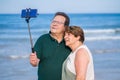 Modern sweet and loving mature couple taking selfie portrait- senior retired husband and wife on their 70s enjoying beach walk Royalty Free Stock Photo