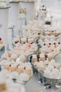 modern sweet table at celebration. stylish candy bar with delicious cakes, cookies, cupcakes with fruits in pink and white colors