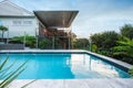 Modern swimming pool with blue water beside a house Royalty Free Stock Photo