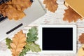 Modern tablet. Autumn leaves. Gray notebook