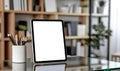 Modern tablet with a blank white screen standing on a glass surface in a contemporary office Royalty Free Stock Photo