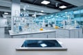 Modern tablet device resting on desk in bright laboratory setting with scientific glassware and equipment blurred in background Royalty Free Stock Photo