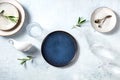 Modern tableware, overhead flat lay shot with a blue plate and olive branches Royalty Free Stock Photo