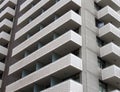 modern tall white concrete apartment block with geometric angular balconies