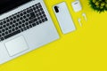 Modern Tech Workspace With Laptop, Smartphone, AirPods And Plant On Bright Yellow Background.Ideal for tech, work, and lifestyle t Royalty Free Stock Photo