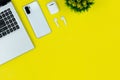 Modern Tech Workspace With Laptop, Smartphone, AirPods And Plant On Bright Yellow Background.Ideal for tech, work, and lifestyle t Royalty Free Stock Photo