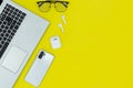 Modern Tech Workspace With Laptop, Smartphone, AirPods And Plant On Bright Yellow Background.Ideal for tech, work, and lifestyle t Royalty Free Stock Photo