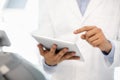 Modern Technologies And Dentistry. Male Dentist Using Digital Tablet In Clinic, Closeup