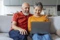 Modern Technologies. Smiling Senior Couple Using Laptop Together At Home Royalty Free Stock Photo