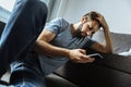 Depressed handsome man using his smartphone Royalty Free Stock Photo