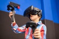 Modern technology, gaming and people concept - boy in virtual reality headset or 3d glasses playing videogame at game