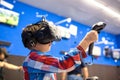 Modern technology, gaming and people concept - boy in virtual reality headset or 3d glasses playing videogame at game