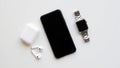Modern technology setup featuring smartphone earbuds and smartwatch Royalty Free Stock Photo