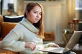 Modern teen girl doing research while sitting near couch Royalty Free Stock Photo