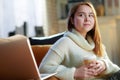 Modern teenage girl with cup of hot beverage and laptop Royalty Free Stock Photo