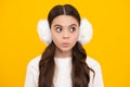 Modern teenage girl 12, 13, 14 year old wearing sweater and winter warm earmuff ear-flaps on  yellow background Royalty Free Stock Photo