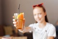 Modern teenager holding refreshing cocktail in her hands