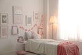 Modern teenager`s room interior with comfortable bed and beautiful pictures Royalty Free Stock Photo