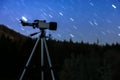 Modern telescope under night sky with star trails outdoors. Learning astronomy Royalty Free Stock Photo