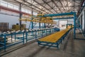 Modern thermal insulation sandwich panel production line. Machine tools, roller conveyor and overhead crane in workshop