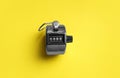 Modern timer on yellow background, top view