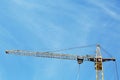 Modern tower crane against blue sky. Construction site, low angle view Royalty Free Stock Photo