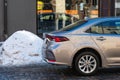 A modern Toyota Corolla sedan parked on the side of the street, close-up side view of the rear part Royalty Free Stock Photo